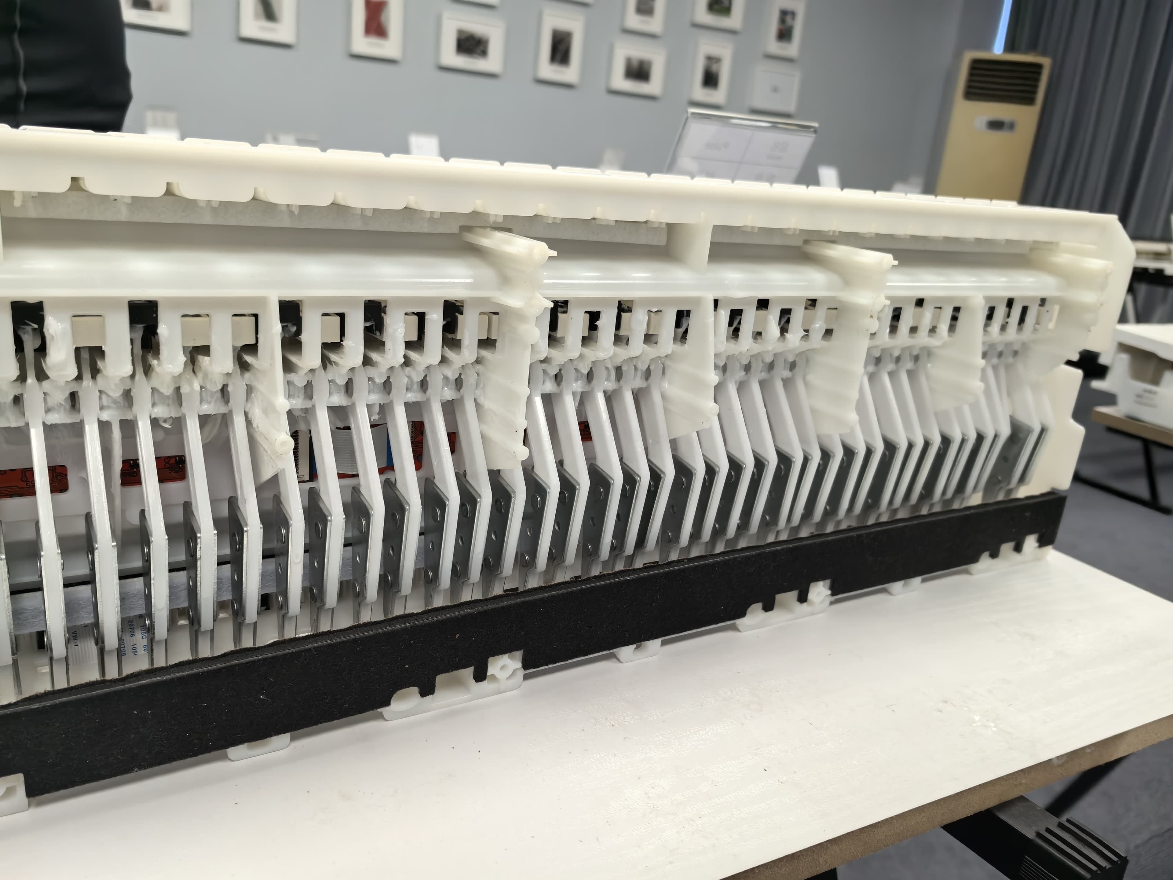 Piano action mechanics showing heavy hammers that drove wider key design